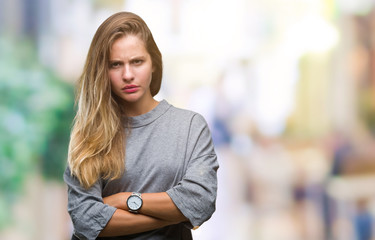 Young beautiful blonde woman over isolated background skeptic and nervous, disapproving expression on face with crossed arms. Negative person.