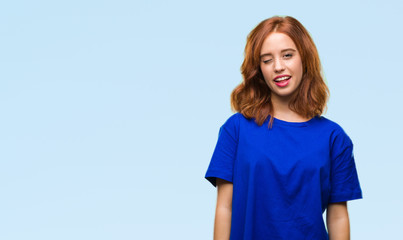 Young beautiful woman over isolated background winking looking at the camera with sexy expression,...