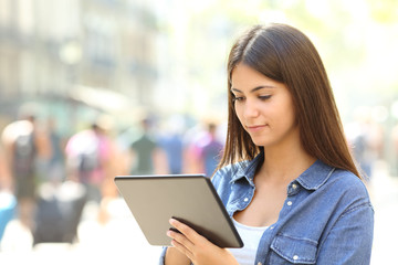 Obraz na płótnie Canvas Teen is using a tablet in the street