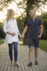 Fototapeta premium young couple, talking to each other, holding hands. walking in park trail.