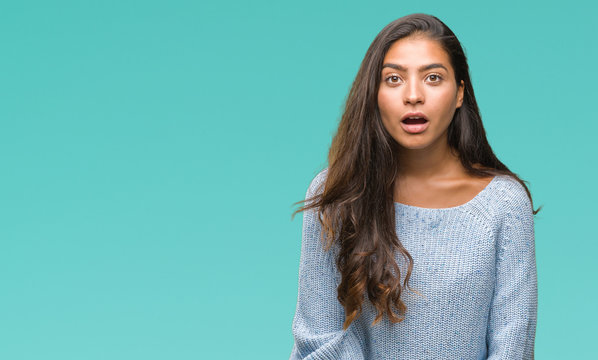 Young beautiful arab woman wearing winter sweater over isolated background afraid and shocked with surprise expression, fear and excited face.