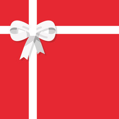 White ribbon with bow on red background