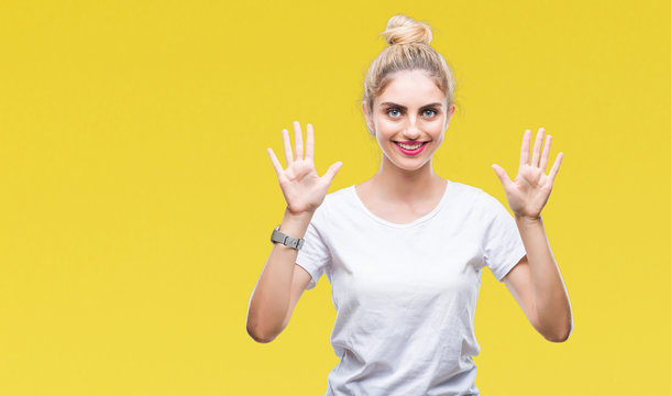 Young beautiful blonde woman wearing white t-shirt over isolated background showing and pointing up with fingers number ten while smiling confident and happy.