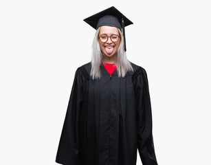 Young blonde woman wearing graduate uniform over isolated background sticking tongue out happy with funny expression. Emotion concept.