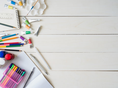 Back to school concept and artist kid concept with Drawing book, crayons, coloured pencils, Poster color and School stationery on wooden table background.