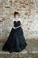 evil Queen in a black ball gown reads the book of witchcraft conceived evil