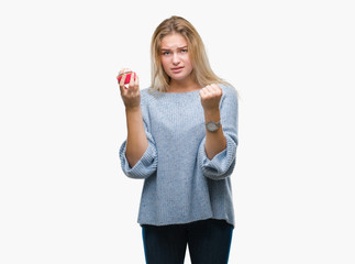 Young caucasian woman eating sweet cupcake over isolated background annoyed and frustrated shouting with anger, crazy and yelling with raised hand, anger concept