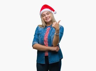 Young caucasian woman wearing christmas hat over isolated background doing happy thumbs up gesture with hand. Approving expression looking at the camera with showing success.