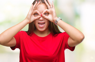 Young beautiful caucasian woman over isolated background doing ok gesture like binoculars sticking tongue out, eyes looking through fingers. Crazy expression.