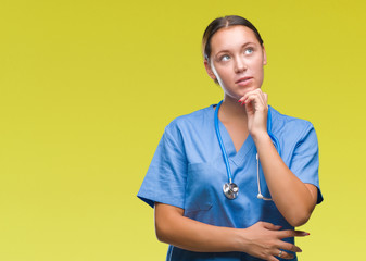 Young caucasian doctor woman wearing medical uniform over isolated background with hand on chin...