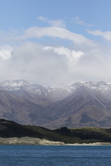 Moody fog and clouds surrounding snow covered mountains