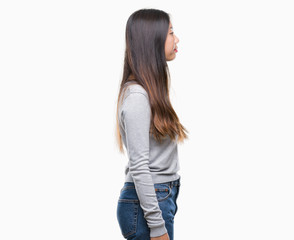 Young asian woman over isolated background looking to side, relax profile pose with natural face with confident smile.