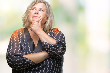 Senior plus size caucasian woman over isolated background with hand on chin thinking about question, pensive expression. Smiling with thoughtful face. Doubt concept.