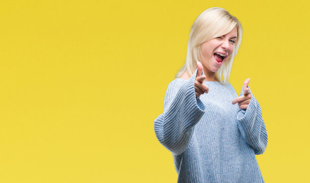 Young beautiful blonde woman wearing winter sweater over isolated background pointing fingers to camera with happy and funny face. Good energy and vibes.