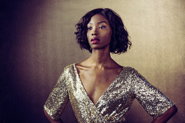 Portrait of a beautiful woman in golden sequin dress waiting for her dreams