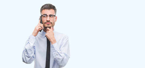 Young business adult man talking on the phone serious face thinking about question, very confused idea