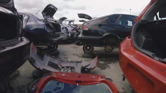 Many cars inside a junkyard being salvage for car parts. Vehicle recycling industry