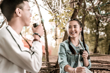 Eye contact. Attractive girl expressing positivity while going to drink tea