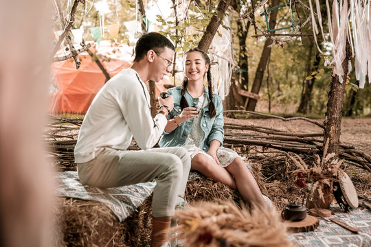 Moment of happiness. Pleased man sitting in semi position and talking to his girlfriend