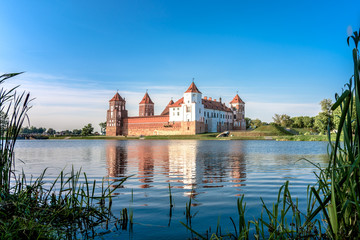 Naklejka na ściany i meble Mir Castle in Belarus. The castle is reflected in the lake opposite it