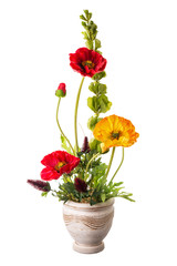 Floral arrangement from artificial poppy flowers in old ceramic flower pot.