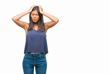 Young asian woman over isolated background suffering from headache desperate and stressed because pain and migraine. Hands on head.
