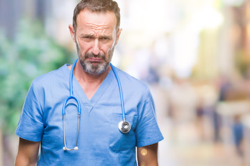 Middle age hoary senior doctor man wearing medical uniform over isolated background depressed and...