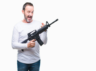 Middle age senior hoary criminal man holding gun weapon over isolated background very happy pointing with hand and finger