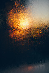 Fototapeta na wymiar Rain drop with moisture on the glass with evening light on the street background