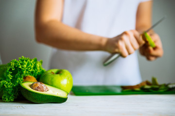 green fruits on front. woman cut fruits on background. healthy food concept