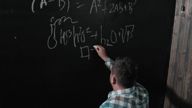 A brilliant mature mathematician brings a big board and completes an essay Complicated mathematical formula equation
