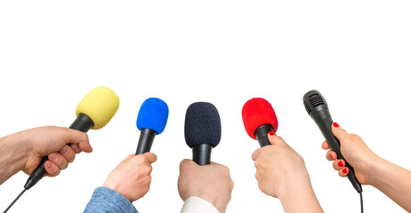 Hands of reporters with many microphones isolated on white