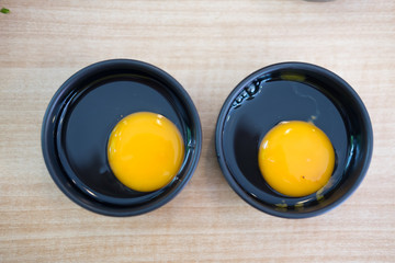 Fresh raw egg in black bowl