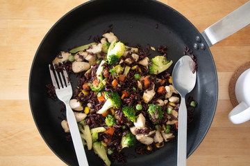 Healthy black fired rice chicken breast on hot pan.