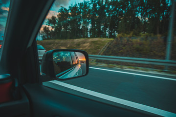 car on highway. sunset in car mirror reflection