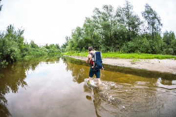 A man with a child crosses the river ford.