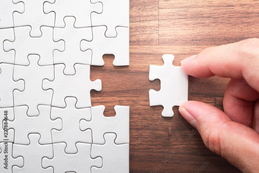 Poster Putting last jigsaw puzzle piece. Solving and completing the task. The correct solution. Assembling white jigsaw puzzle pieces.
