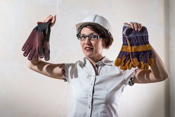 Cute young woman in white construction protection building helmet in unfinished apartment © keleny
