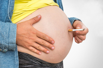 Pregnant woman with cigarette - smoking addiction concept