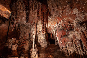 Big stalactites hanging down the ceiling in a limstone cave