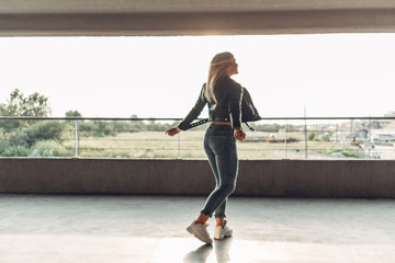 Obraz premium Beauty Girl in a Black Leather Jacket at the Parking Garage