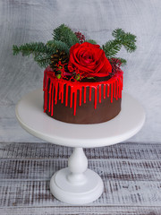 New year color drip chocolate cake with red roses and fur tree