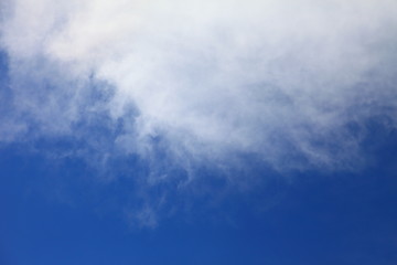 Bright blue sky with white fluffy beautiful crescent cloud formation on sunny day for design background and wallpaper