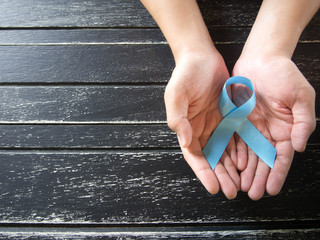 Prostate cancer awareness campaign and Men's Health care concept. Human hands holding light blue...