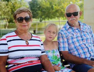 Grandparents And Granddaughter Enjoying Day In Park