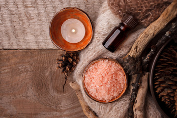 Wood scents for winter time aromatherapy. Pine cones, candles, essential oil bottles, top view. Spa relax winter concept, copy space