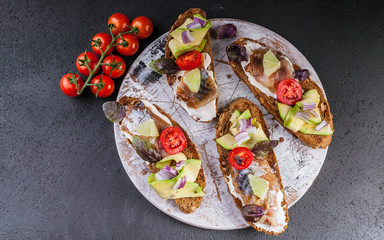 Sandwiches with smoked mackerel, avocado and red onion.