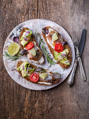 Sandwiches with smoked mackerel, avocado and red onion. Top view. Vertical shot