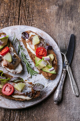 Sandwiches with smoked mackerel, avocado and red onion. Top view. Vertical shot. Close Up