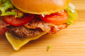 Delicious fresh homemade grilled burger on a wooden table with copyspace